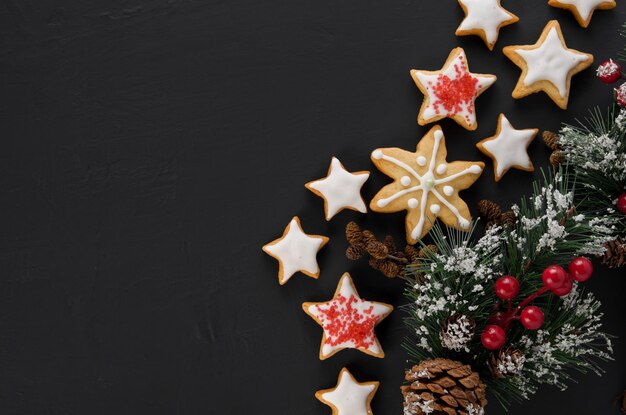 Galho de árvore de natal com bagas vermelhas feito em casa biscoitos em forma de estrela com glacê