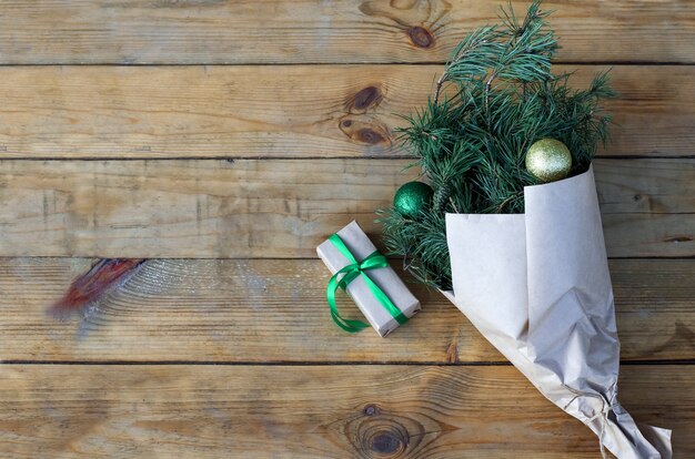 Galhos da árvore de Natal no papel artesanal em um fundo de madeira Buquê de Natal sem resíduos