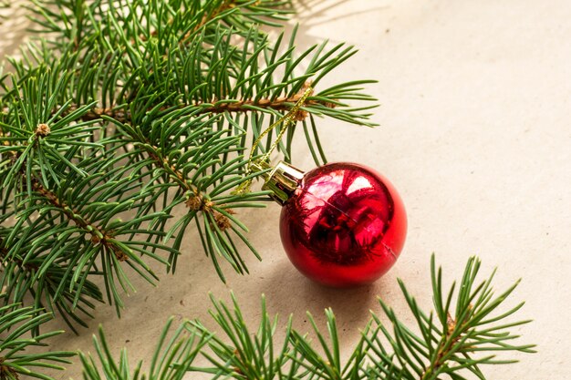 Galhos de árvore do abeto decorados com bolas vermelhas de Natal como fronteira em um feriado rústico