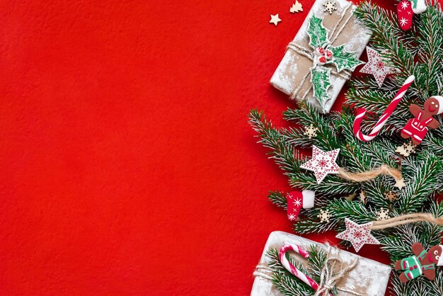 Galhos de árvores de Natal em um fundo de madeira. O conceito de presentes e feriados de ano novo. Copie o espaço. Fundo de madeira vermelho.