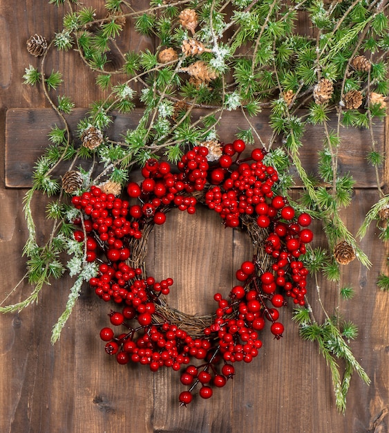 Galhos de árvores de Natal verdes e grinalda de frutas vermelhas