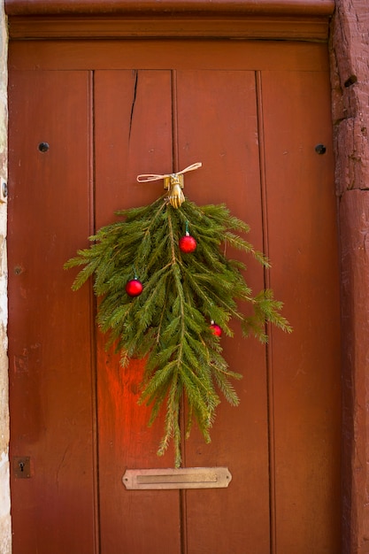 Galhos e bolas de árvores de Natal decoram a porta vintage