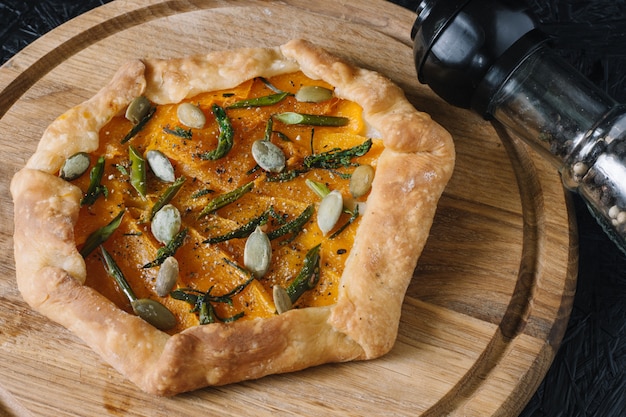 Gallet con calabaza sobre tabla de madera