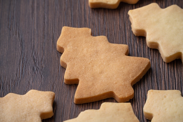 Galleta de árbol de Navidad de pan de jengibre sobre mesa de madera