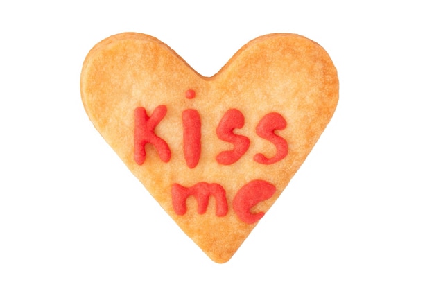 Galleta de corazón casera con letras KISS ME para el día de San Valentín aislado en blanco, plano. Pastelería artesanal para regalo romántico.