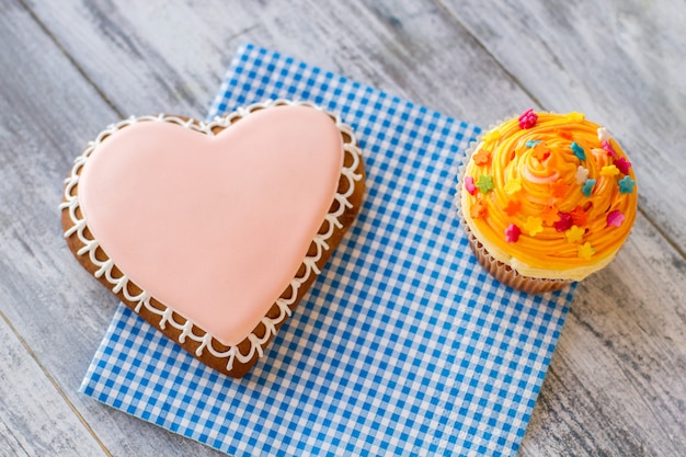 Galleta De Corazón Y Magdalena Naranja Vista Superior De Postres De Confitería En La Mesa De Madera Gris Vacaciones Para El Día De Fiesta.