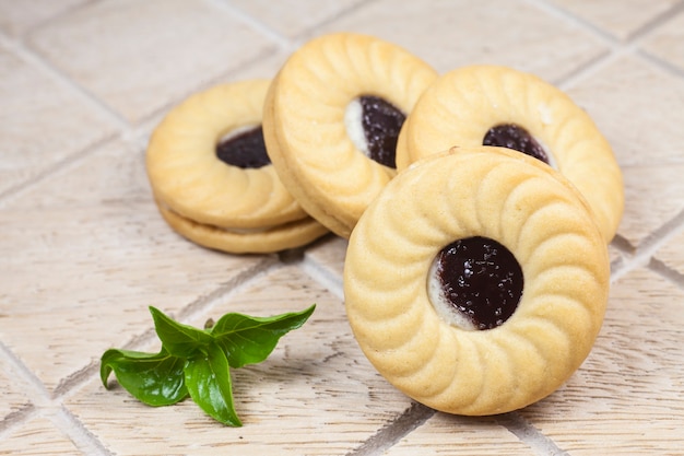 Galleta con crema y mermelada de arándanos