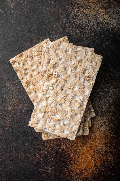 Galleta crujiente de centeno fino en la vista superior del fondo de la mesa rústica oscura vieja endecha plana