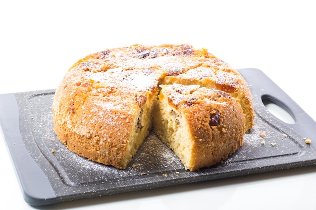 Galleta dulce cocida con albaricoques secos y nueces en el interior aislado sobre fondo blanco.