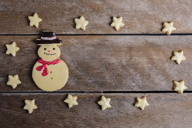 Galleta festiva de Navidad y año nuevo en forma de muñeco de nieve, copo de nieve, estrella en mesa de madera