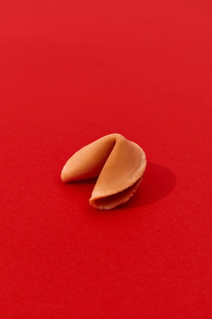 Foto galleta de la fortuna sobre un fondo rojo con una plantilla de fondo de sombra larga y profunda para restaurante