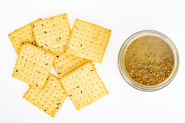 Galleta de galletas con hierbas secas y especias sobre fondo blanco. Foto de estudio