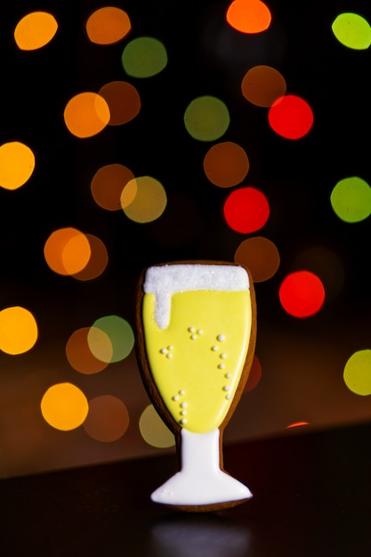 Galleta de jengibre de copa de champán sobre luces de colores desenfocadas