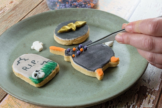 Galleta mantecosa, en forma de caldero, siendo decorada por el panadero con bolitas de azúcar.