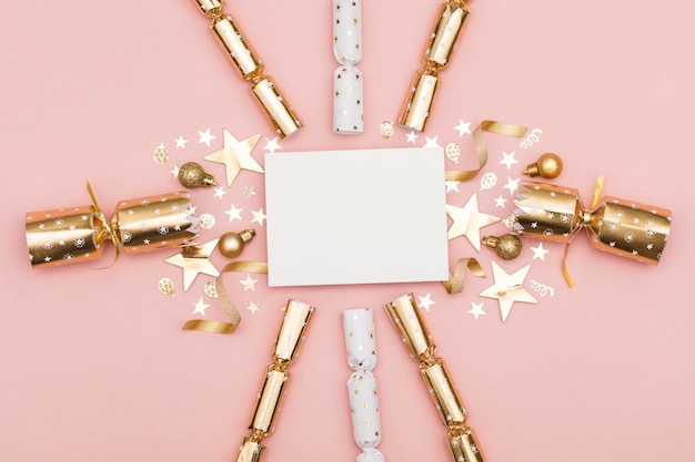 Foto galleta de navidad dorada con una lujosa galleta festiva de oro de etiqueta blanca en blanco sobre un fondo rosa pastel