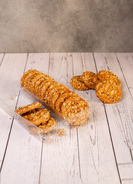 Galletas americanas con trozos de semillas, dispuestas en una pila sobre un fondo claro.