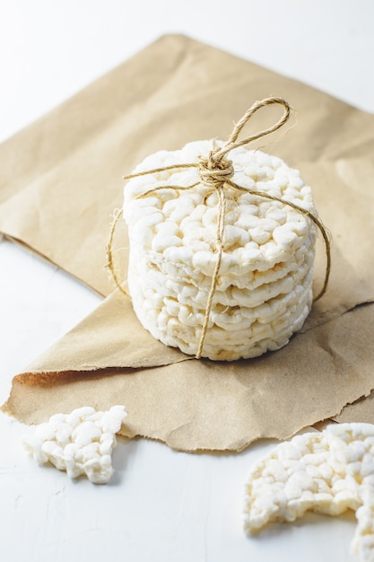 Galletas de arroz atadas con cordón rústico sobre papel cartón.