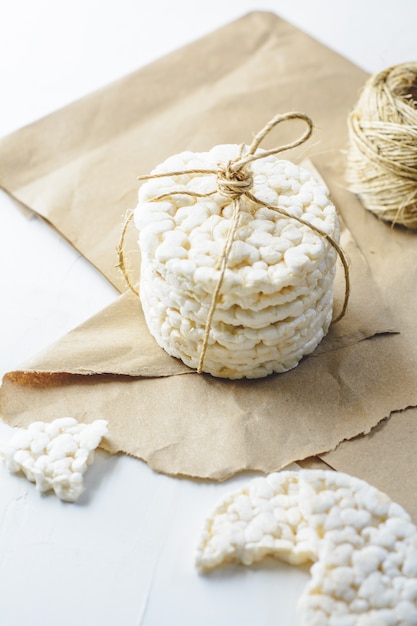 Galletas de arroz atadas con cordón rústico sobre papel cartón.