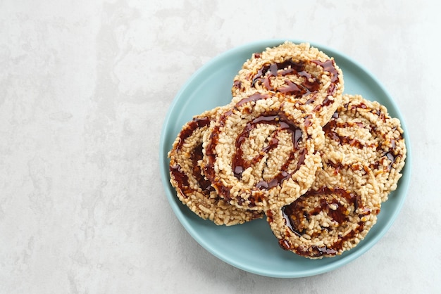 Galletas de arroz intip madu o rengginang con azúcar moreno sobre fondo blanco Sabroso y dulce