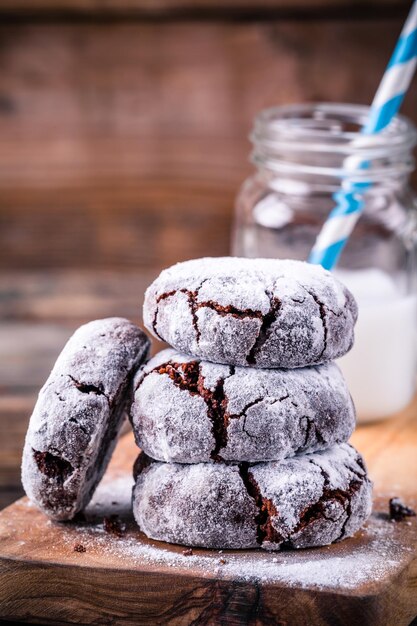 Galletas arrugadas de chocolate con glaseado de azúcar en polvo para navidad sobre fondo de madera