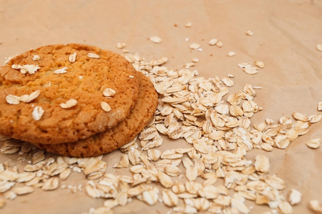 Galletas de avena y avena esparcida sobre fondo de papel arrugado