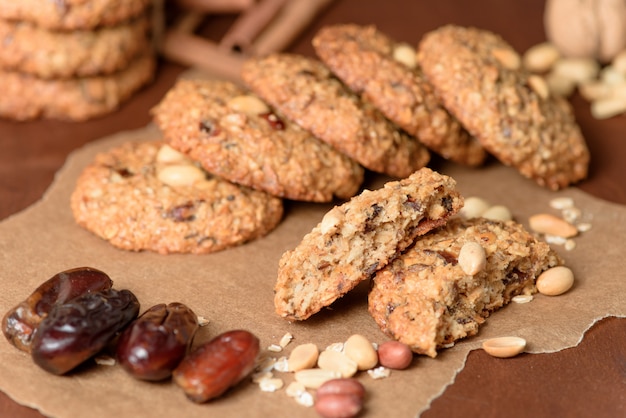 Galletas de avena caseras con fechas, cacahuetes, virutas de coco sobre un fondo de madera, primer plano macro. galletas rotas en primer plano