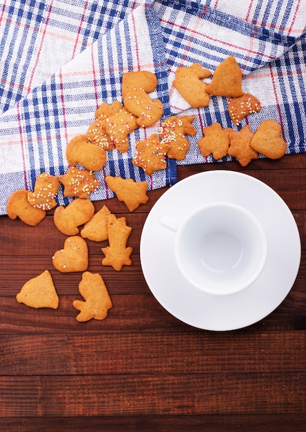 Galletas de avena caseras con una taza de té sobre fondo de madera vieja