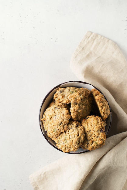 Galletas de avena caseras en un tazón sobre fondo blanco, merienda saludable, espacio de copia