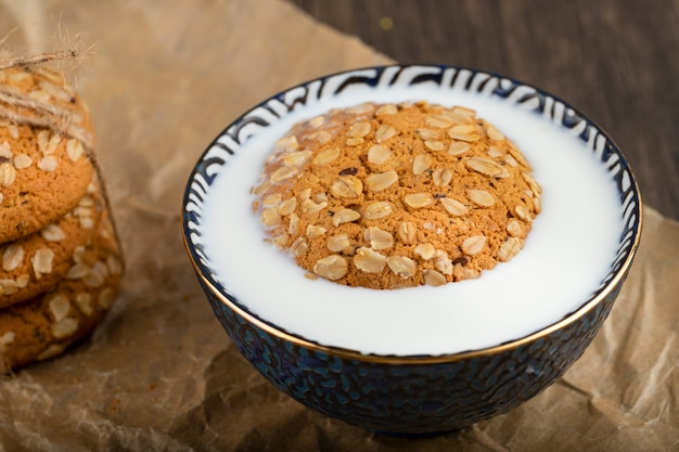 Galletas de avena con cereales y semillas en un cuenco de leche.