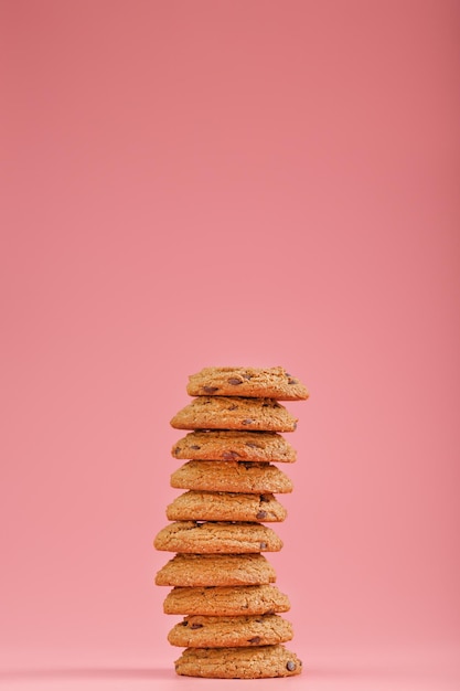 Las galletas de avena con chocolate se apilan sobre un fondo rosa. Espacio libre