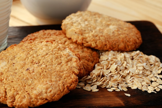 Galletas de avena y copos de avena sobre superficie de madera