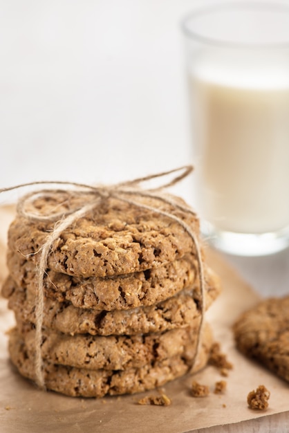 galletas de avena en una cuerda de madera atada junto a un vaso de leche