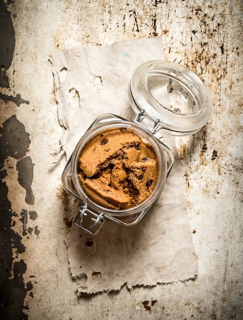 Galletas de avena en un frasco. Sobre una vieja mesa rústica.