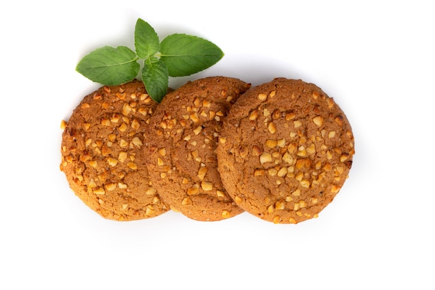 Galletas de avena con una hoja de menta verde sobre un fondo blanco. Comida dietetica.