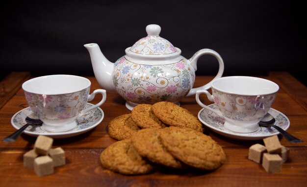 Galletas de avena integrales con una taza de té y azúcar en una mesa de madera