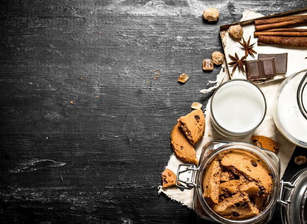 Galletas de avena con leche fresca. Sobre una mesa de madera negra.