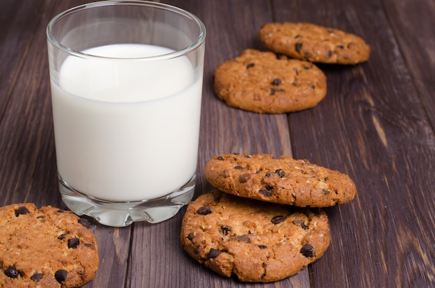 Galletas de avena y leche en la mesa de madera marrón