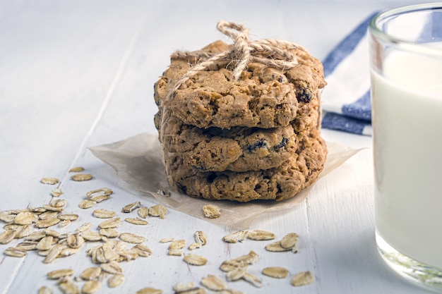 Foto galletas de avena con pasas y chocolate. vaso de leche