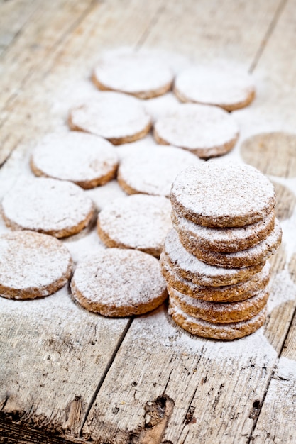 Galletas de avena recién horneadas con polvo de azúcar en la mesa de madera rústica.