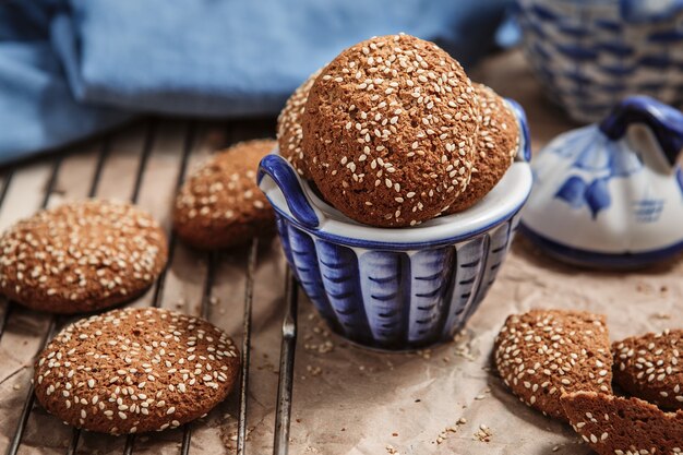 Galletas de avena recién horneadas con semillas de sésamo en una taza. Galletas de sésamo en la parrilla