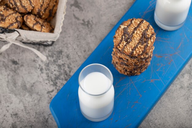 Galletas de avena con semillas y cereales con jarra de vidrio de leche.