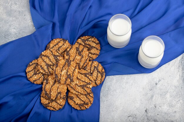 Galletas de avena con semillas y cereales con jarra de vidrio de leche.