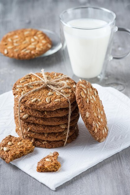 Galletas de avena y una taza de leche en una mesa de madera