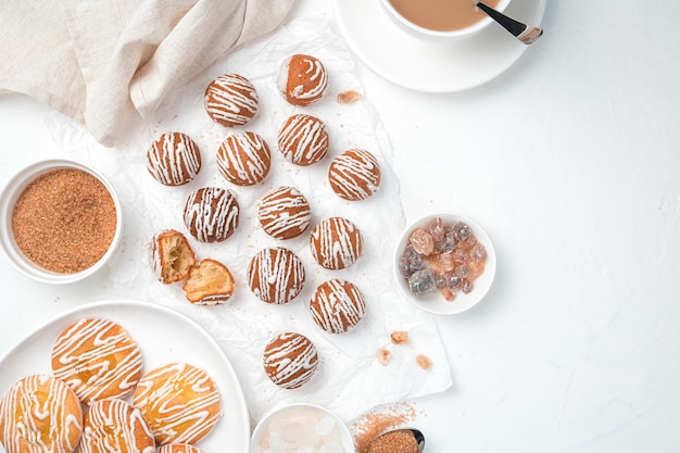 Galletas, azúcar de caña y una taza de café sobre un fondo blanco. Vista superior, horizontal con espacio para