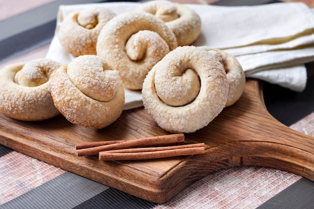 Galletas de azúcar de caracol con canela sobre tabla de madera