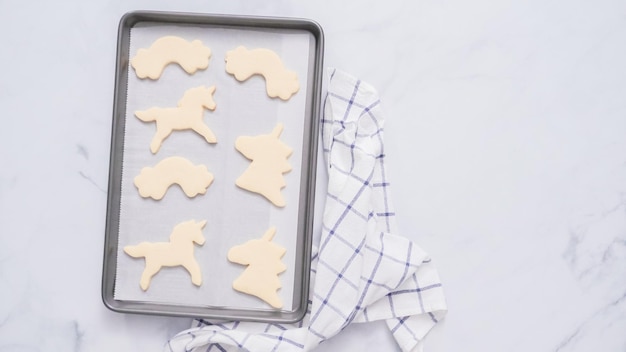 Galletas de azúcar con forma de unicornio en una bandeja para hornear.