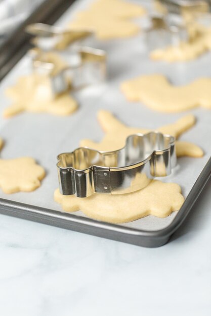 Galletas de azúcar con forma de unicornio sin terminar en la bandeja para hornear.