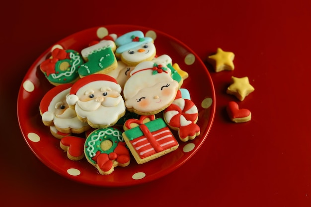 Galletas de azúcar glas de Navidad con fondo rojo y adornos.