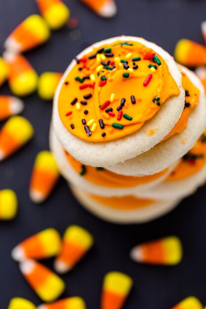 Galletas de azúcar de Halloween con glaseado de naranjas y chispitas en la parte superior.