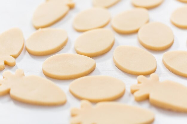 Galletas de azúcar de Pascua sin hornear sobre una mesa blanca.